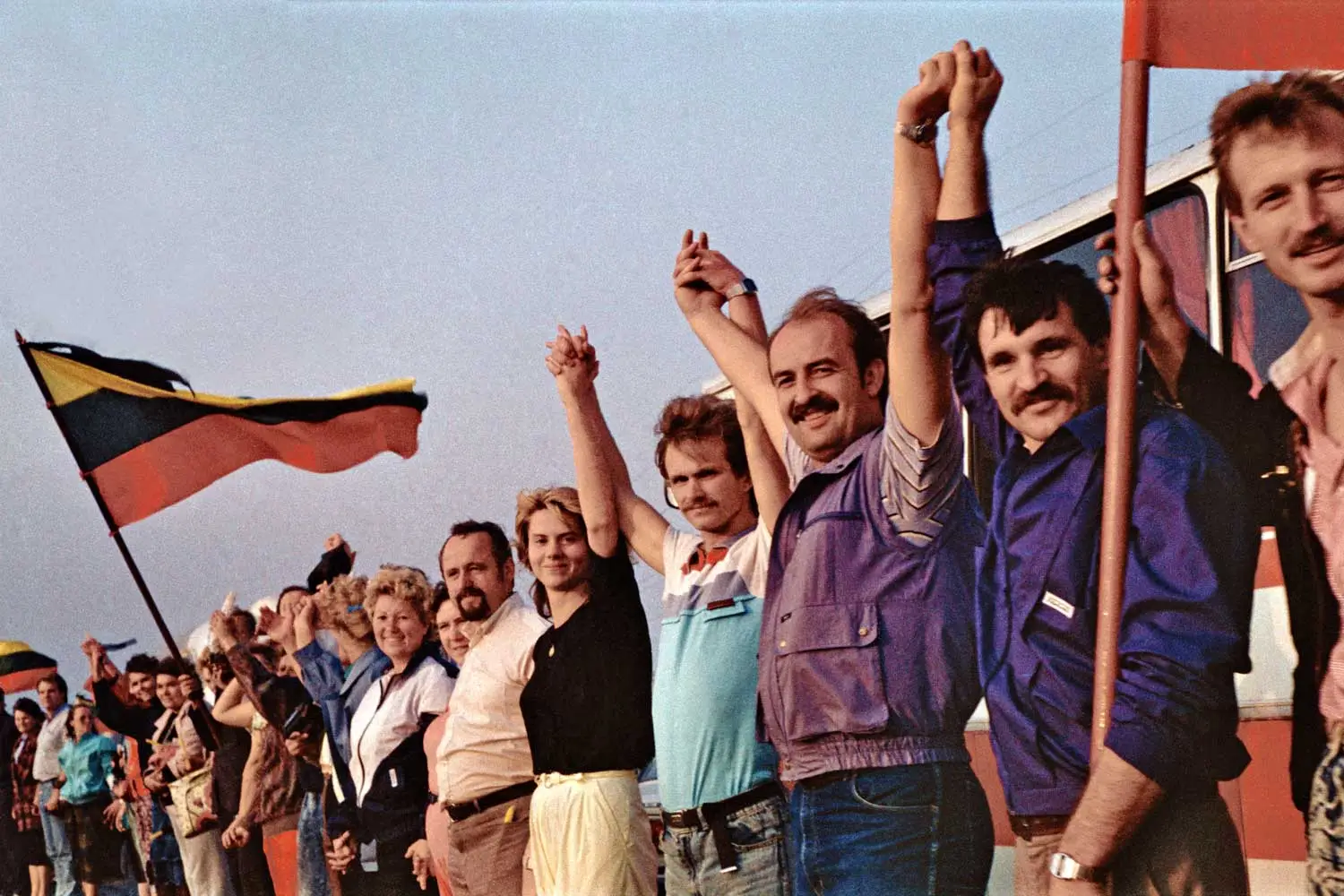 People forming a human chain. Some carry Lithuanian flags.